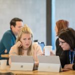 2 people meeting with two surfaces on the table
