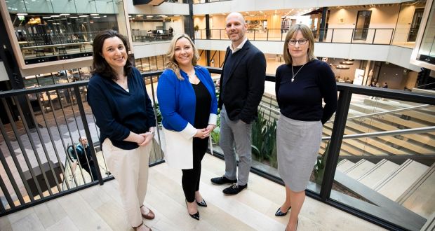 3 women and 1 man standing on a balcony