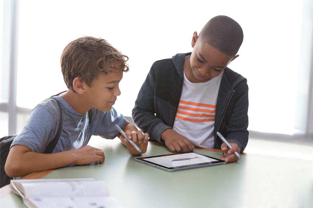 2 kids playing on a Surface Go