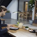 Behind the shoulder photo of a man using Windows Ink on OneNote to edit an architectural rendering for a project.