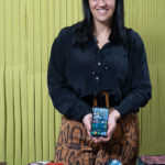 Uma mulher sorridente a agarrar num telemóvel