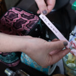 As mãos de uma mulher a segurar um papel onde está escrito