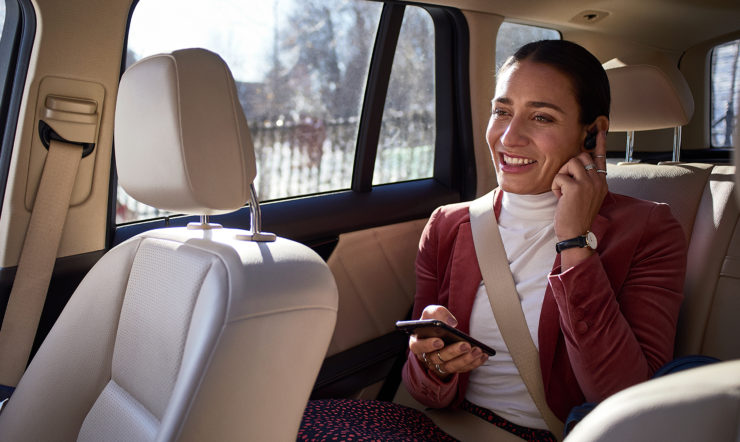 Une femme utilise son téléphone, assise dans un taxi