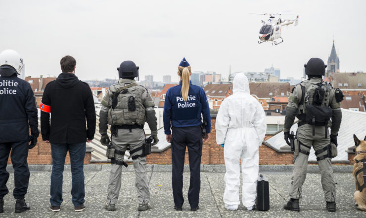 een groep mensen die naast een hond staat