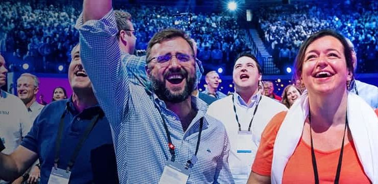 a group of people standing in front of a crowd posing for the camera