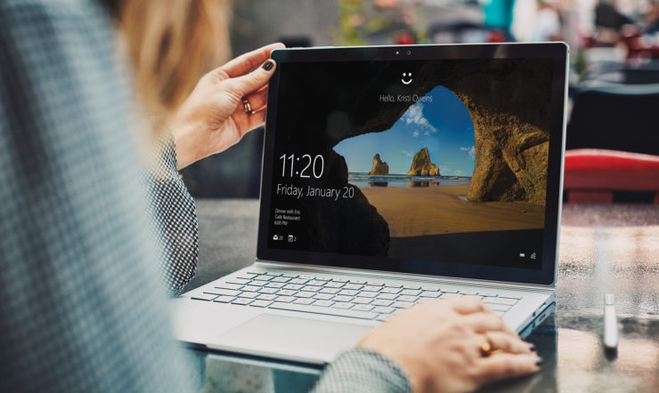 a person sitting at a table using a laptop computer