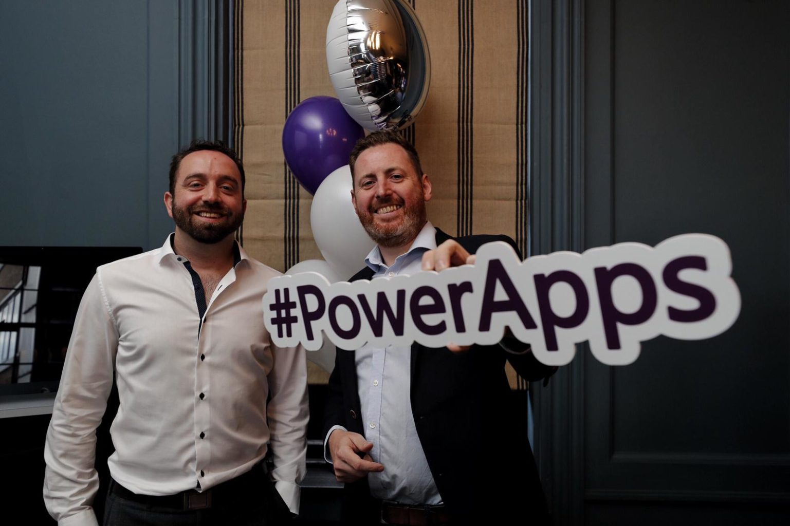 David Arnold & Paul Gilbride holding a PowerApps sign posing for the camera