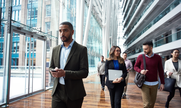 Een man loopt op de voorgrond door een groot gebouw