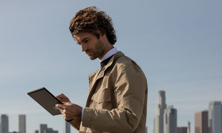 Een man staand aan het werk op een Surface pro X
