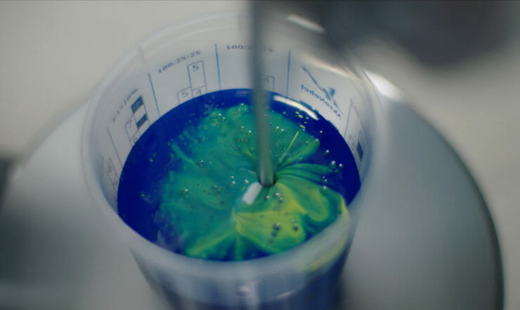 a close up of a bottle with blue and green paint