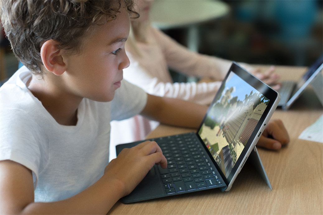 Children, students in classroom playing Minecraft on Surface Go. Contextual education.