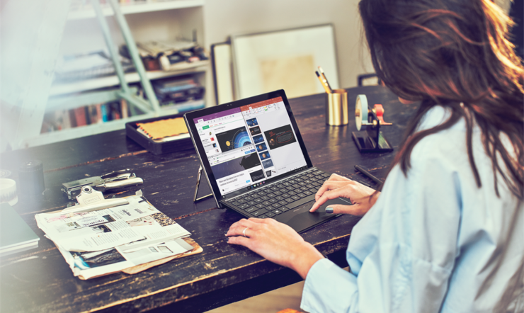 una persona sentada en una mesa usando una computadora portátil