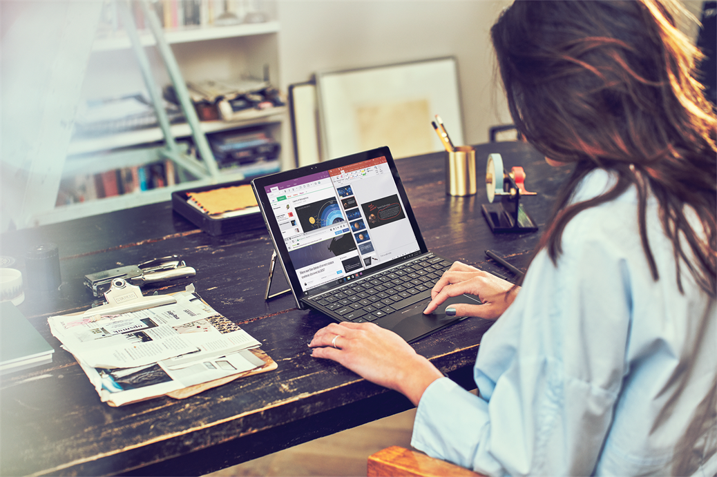 una persona sentada en una mesa usando una computadora portátil