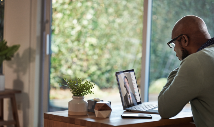 una persona sentada en una mesa usando un ordenador portátil