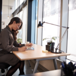 un hombre sentado en un escritorio mirando a un ordenador portátil