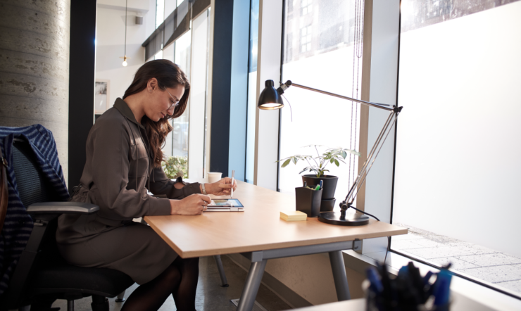 un hombre sentado en un escritorio mirando a un ordenador portátil
