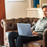 en man som sitter i ett vardagsrum med en läderstol