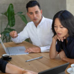 ryhmä ihmisiä istuu pöydässä