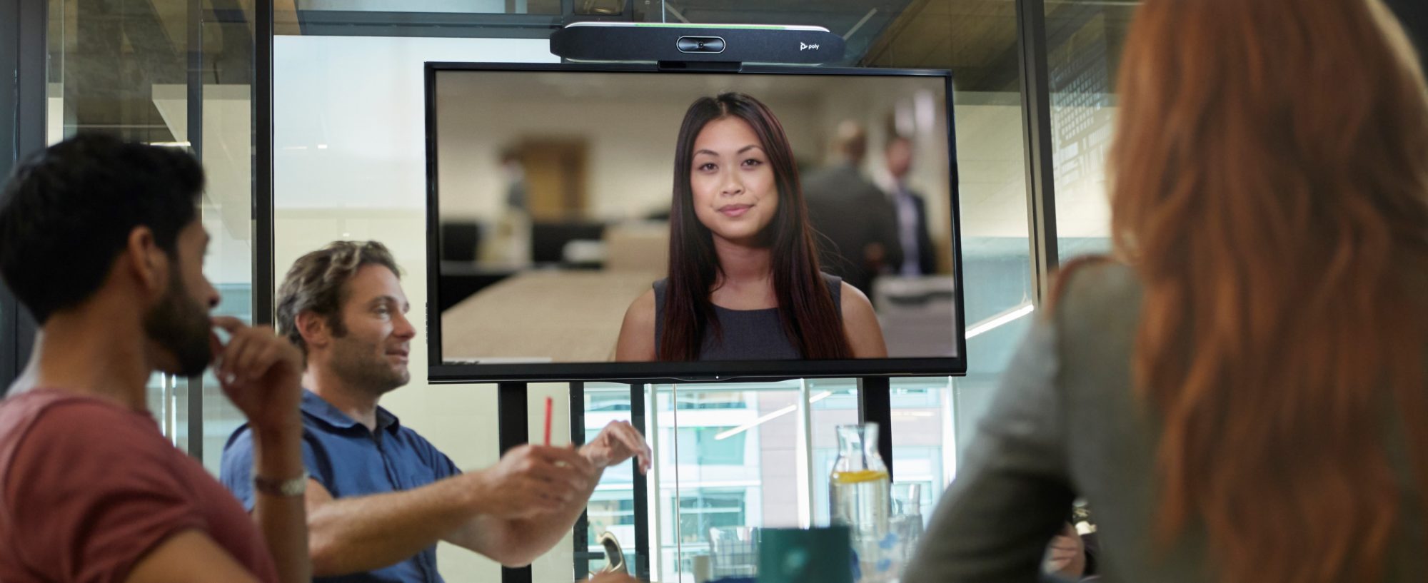 Vrouw op groot scherm tijdens vergadering