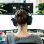 en man som sitter vid ett skrivbord framför ett fönster