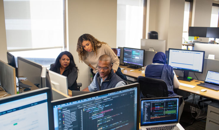 Two females, one mail behind computer screens