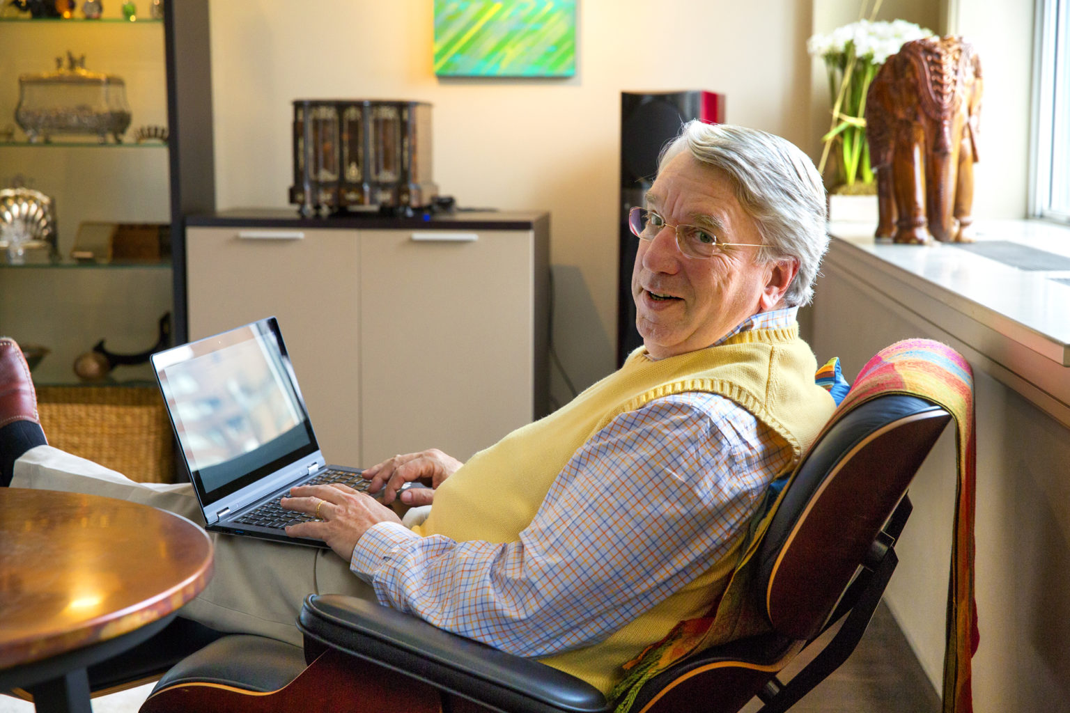 een mensdie bij een lijst zit die laptop gebruikt