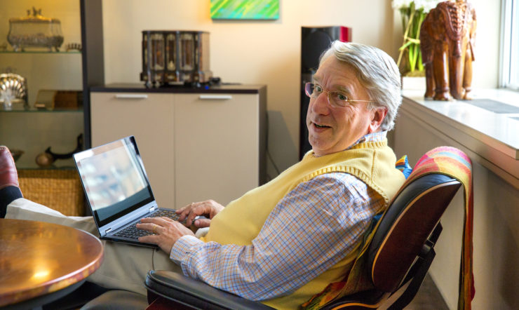 een mensdie bij een lijst zit die laptop gebruikt