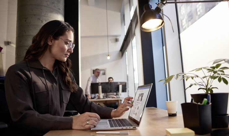 una donna seduta a un tavolo con un computer portatile