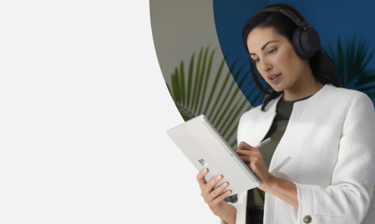 Standing woman writing on a Surface tablet