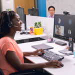 een vrouw die bij een bureau zit en een laptopcomputer gebruikt