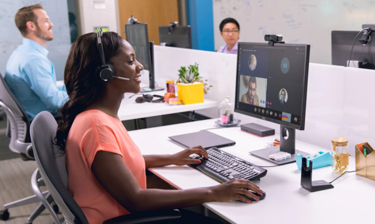 een vrouw die bij een bureau zit en een laptopcomputer gebruikt