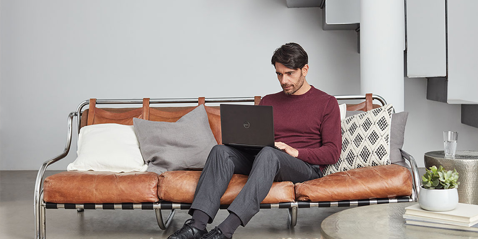a person sitting on a sofa using a laptop