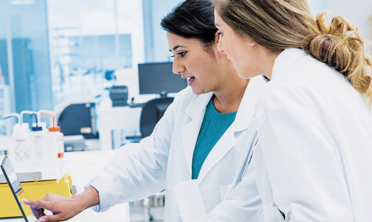 Two female healthcare professionals looking at a tablet