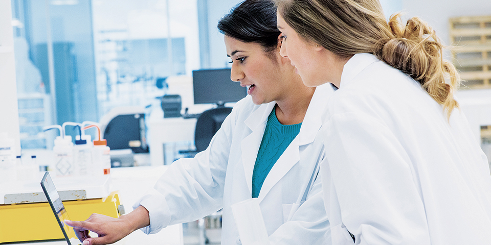 Two female healthcare professionals looking at a tablet