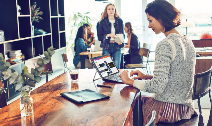 un grupo de personas sentadas en una mesa usando un portátil