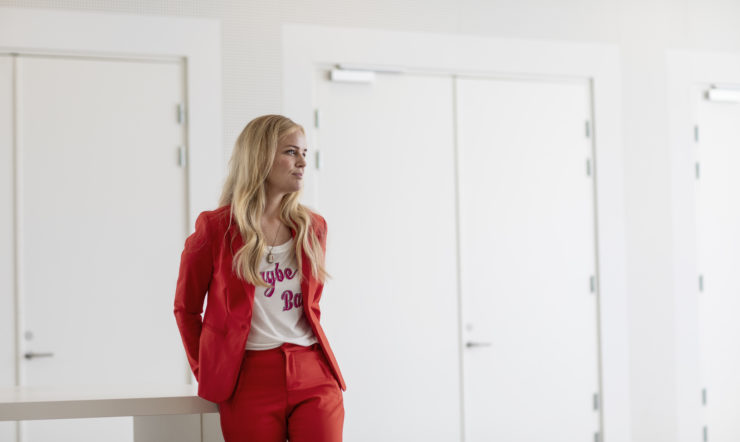 en kvinde stående foran en rød dør