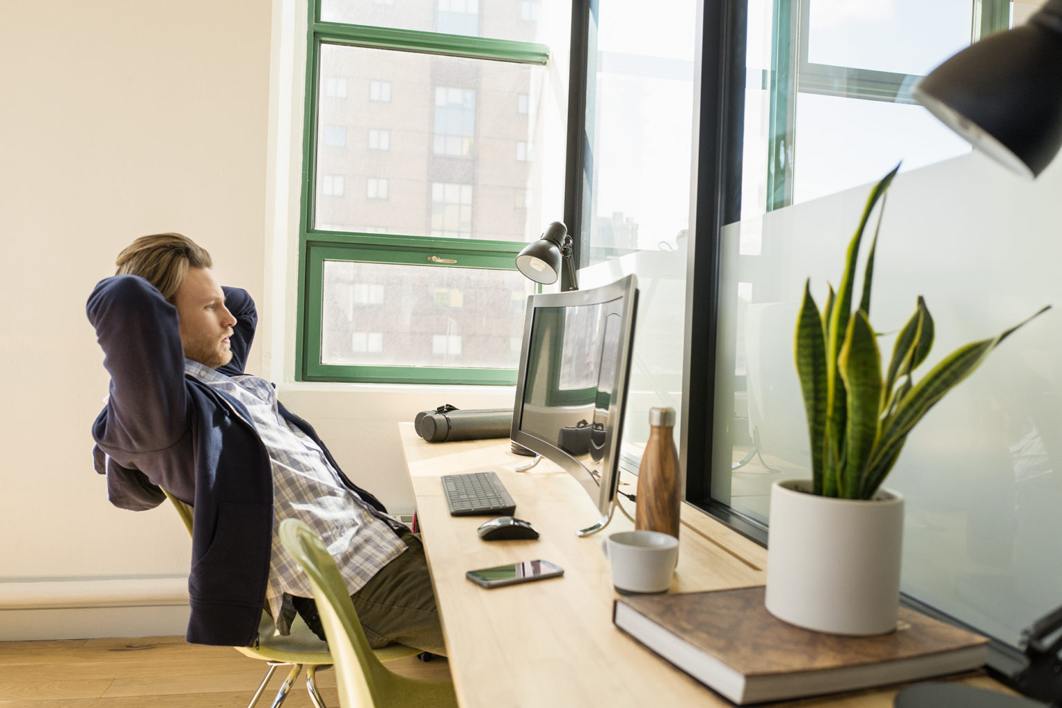 a person sitting at a desk in front of a window