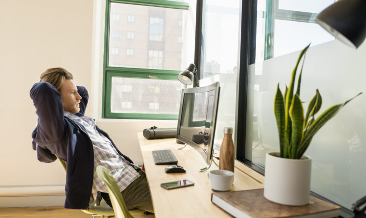 a person sitting at a desk in front of a window