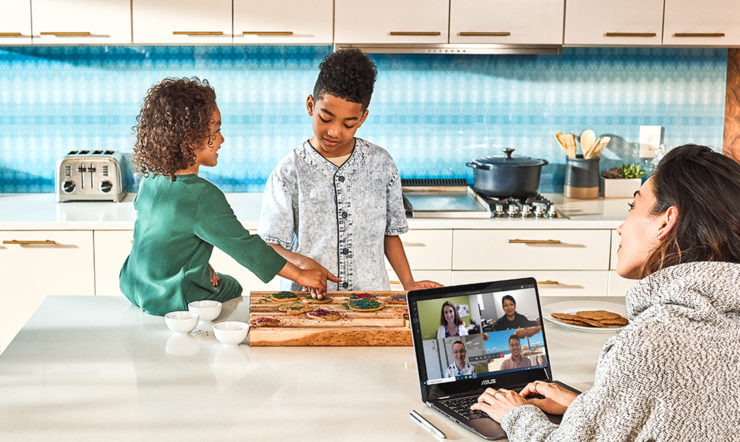 a group of people sitting at a table with a laptop
