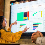 medewerkster laat grafieken zien op digitaal scherm