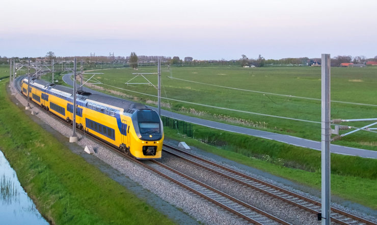 een trein die onderaan treinsporen dichtbij een gebied reist