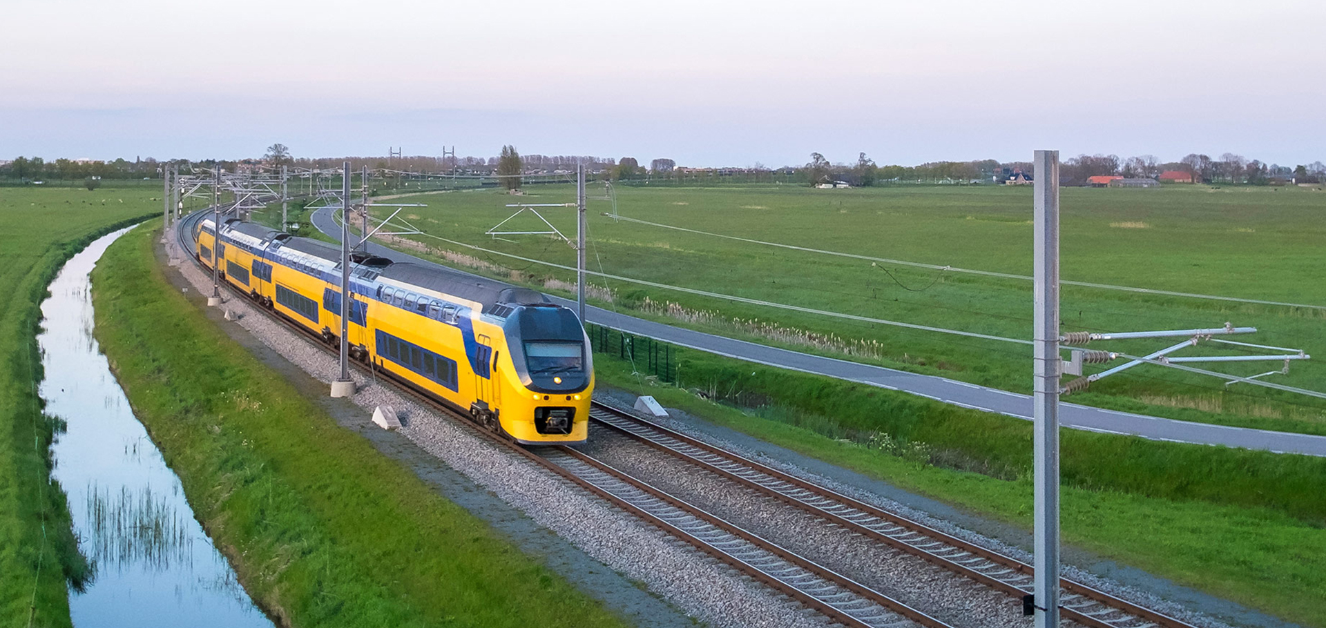 een trein die onderaan treinsporen dichtbij een gebied reist