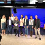 en grupp människor som står framför en tv-