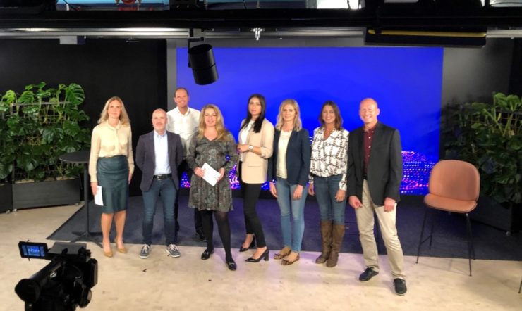 en grupp människor som står framför en tv-