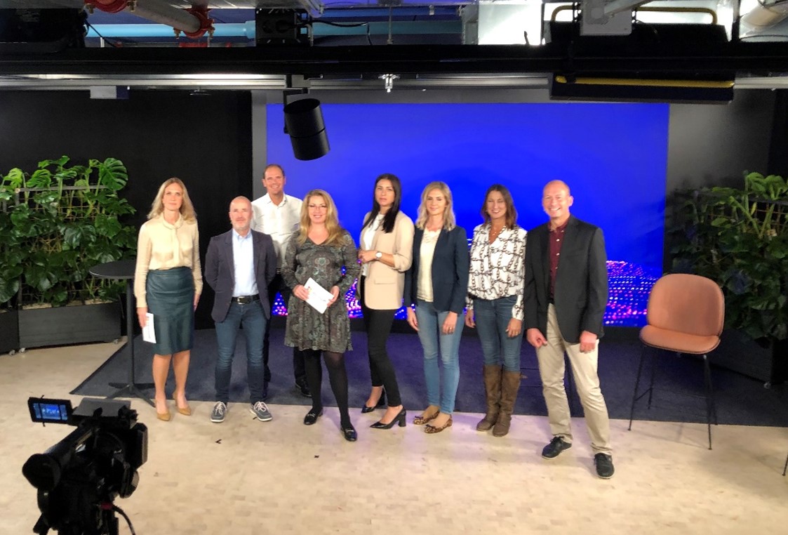 en grupp människor som står framför en tv-