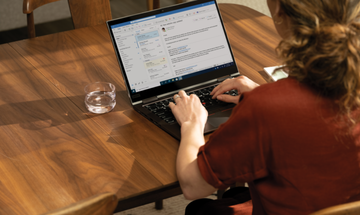 een persoon die bij een lijst met laptop zit