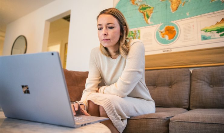 een vrouwenzitting bij een lijst die laptop gebruikt