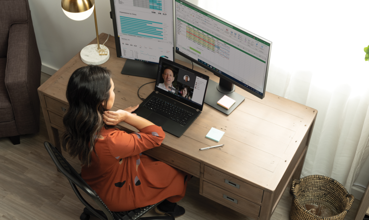 henkilö, joka istuu pöydän ääressä kannettavan tietokoneen edessä