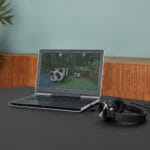 en åben bærbar computer, der sidder oven på et skrivebord