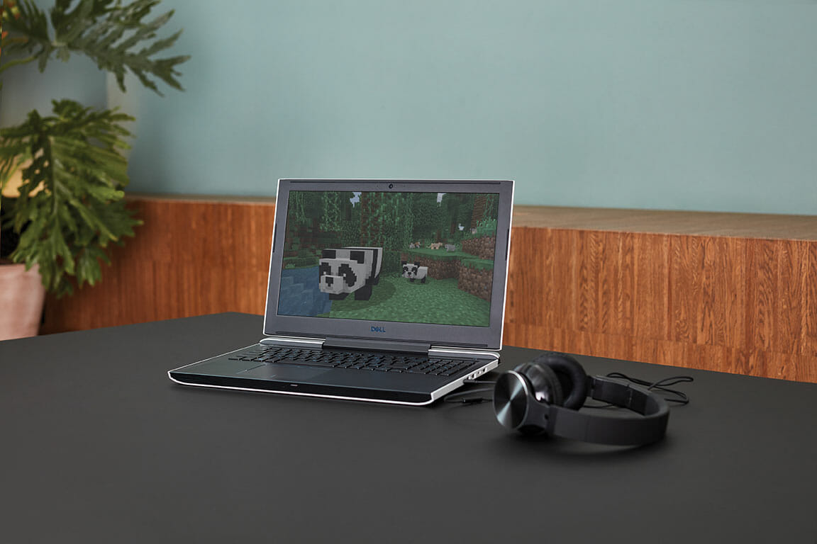 en åben bærbar computer, der sidder oven på et skrivebord